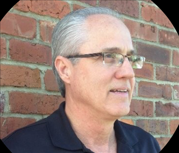 Man in front of brick wall 